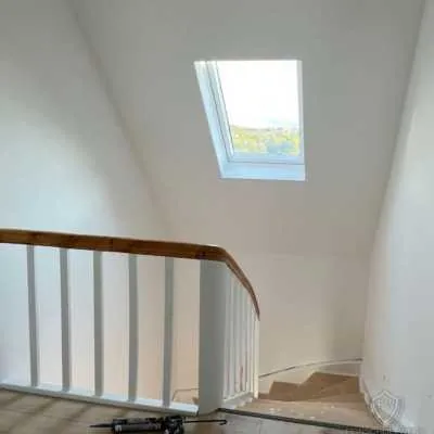 Renoviertes Treppenhaus mit verkleideter Dachschräge und neuem Anstrich