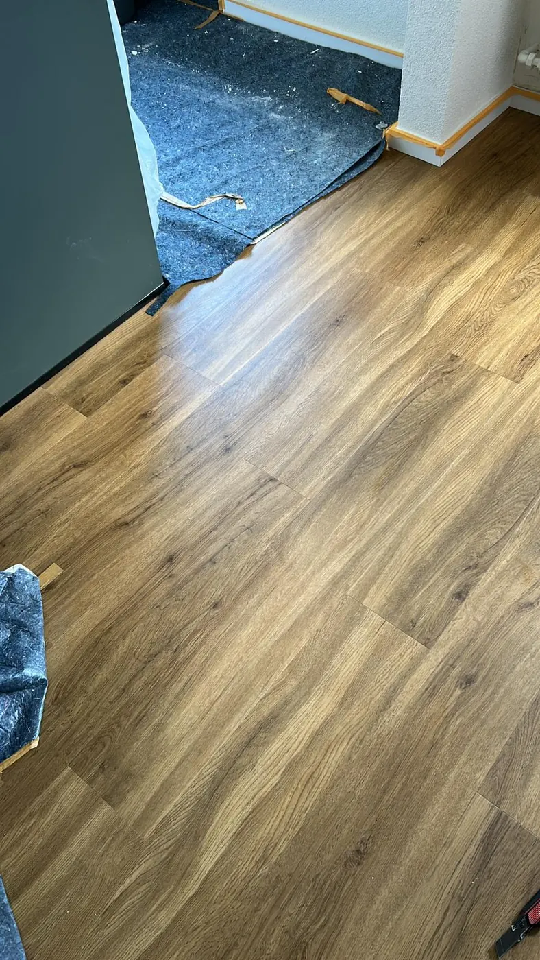 Frisch reparierter Vinyl-Designboden in Eichenoptik am Übergang zum Nachbarraum