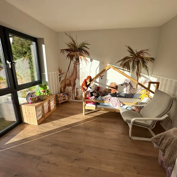 Kinderzimmer mit Dschungel-Fototapete und Laminatboden in Eichenoptik