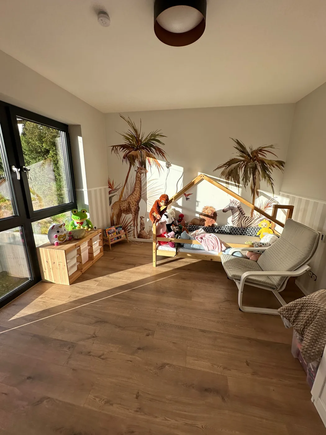 Kinderzimmer mit Dschungel-Fototapete und Laminatboden in Eichenoptik