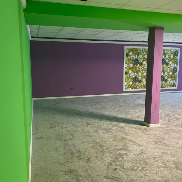 Yogaraum mit grün-lila Wänden und Designertapete in ehemaliger Lagerhalle